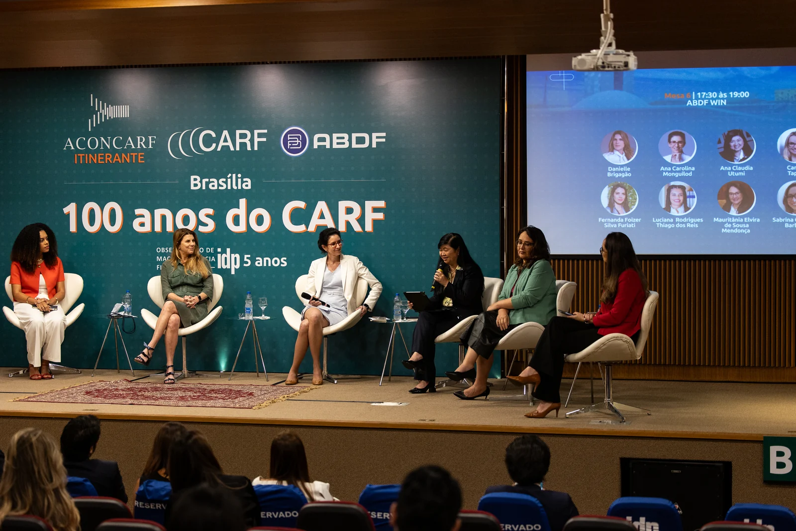 Painel de debatedoras no palco do evento