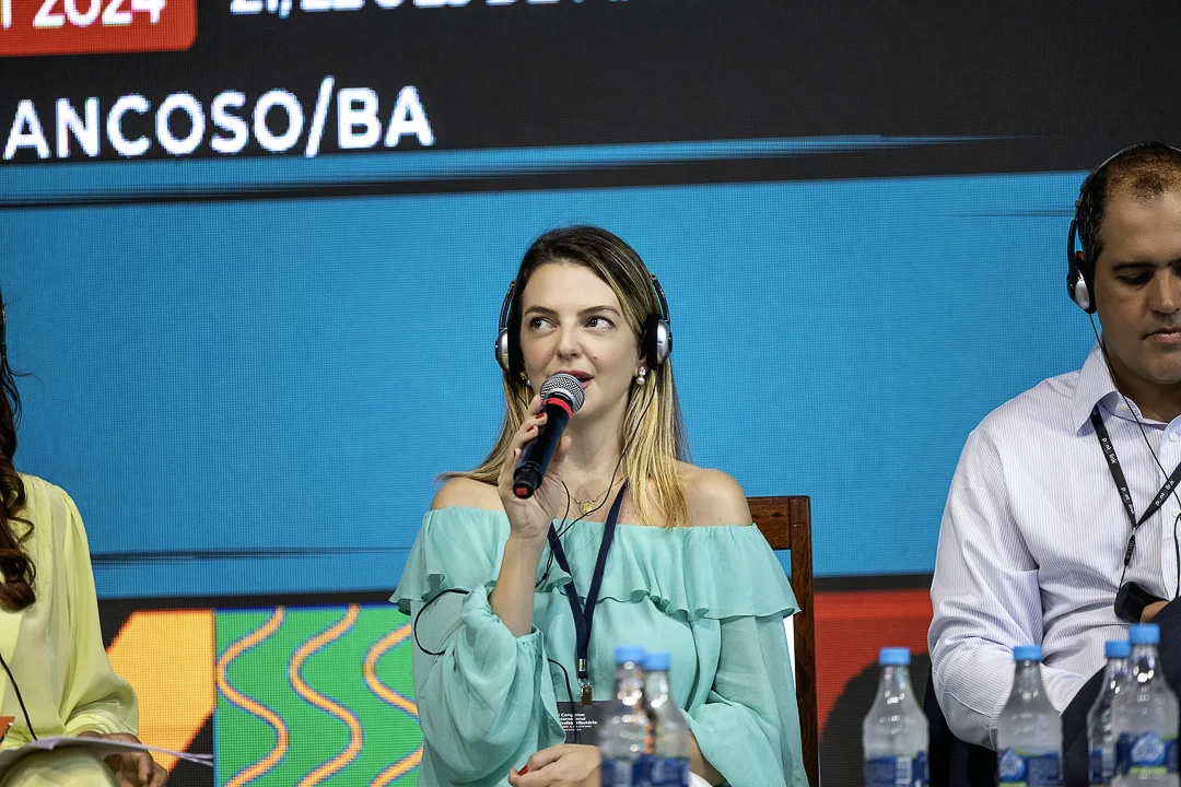 Participante fala ao microfone durante o painel
