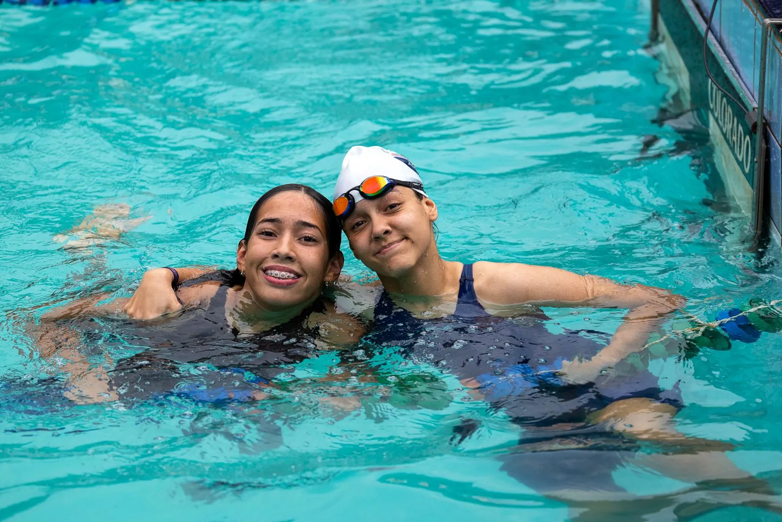 Duas nadadoras comemoram dentro da piscina