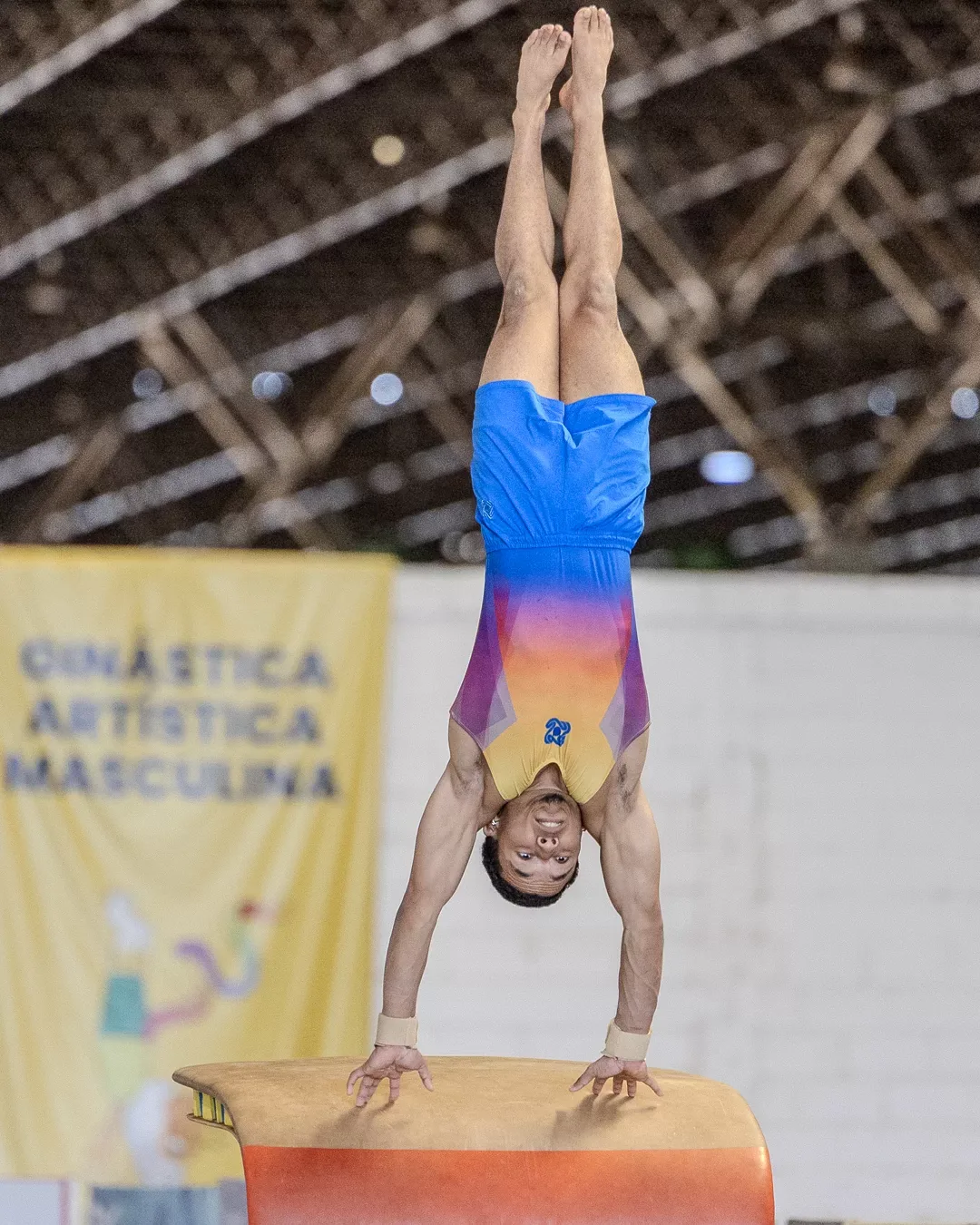 Ginasta em apoio invertido na mesa de salto