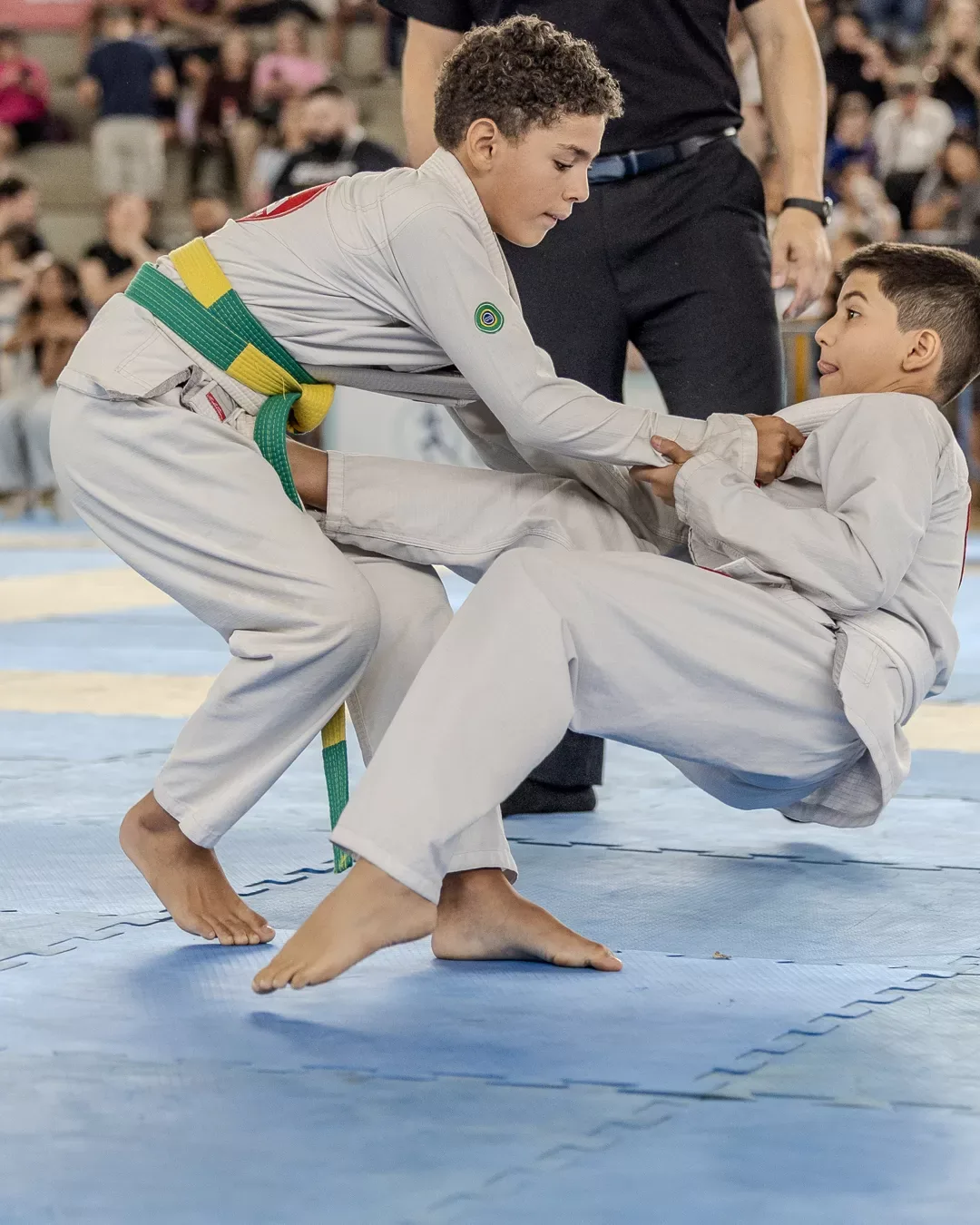 Dois atletas de kimono branco disputando a pegada