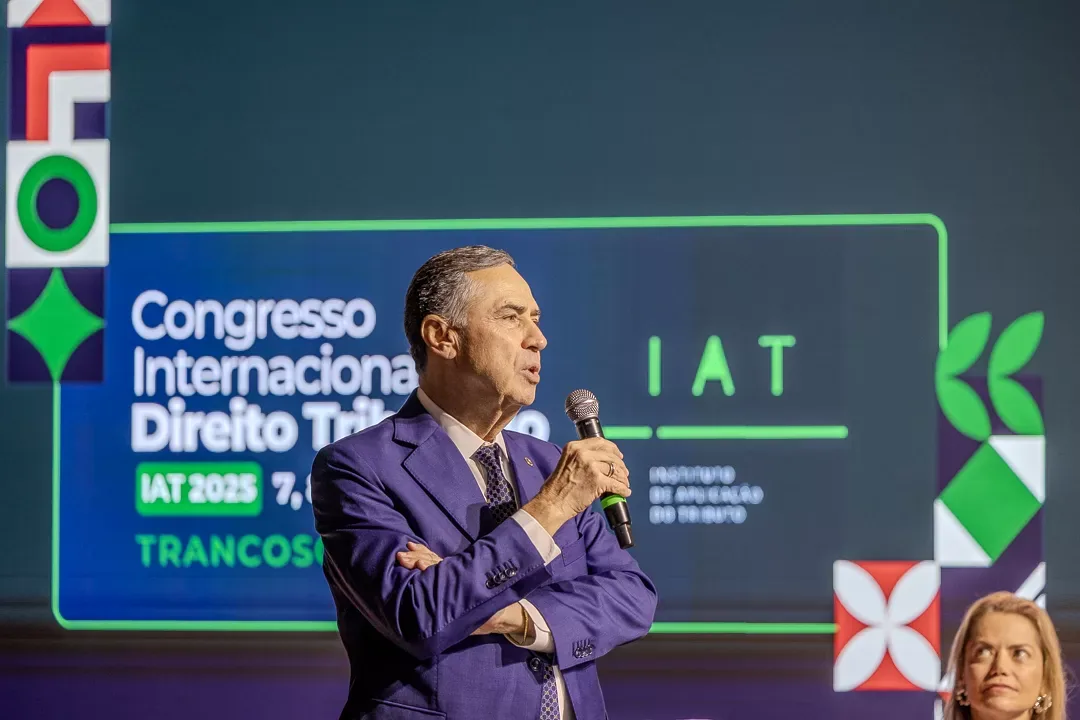 Palestrante fala diante do painel do congresso