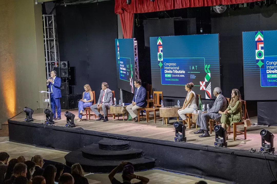 Painel de debate com os convidados no palco