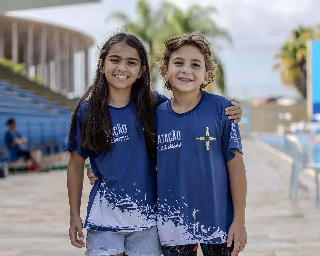 Duas atletas da mesma equipe na área da piscina