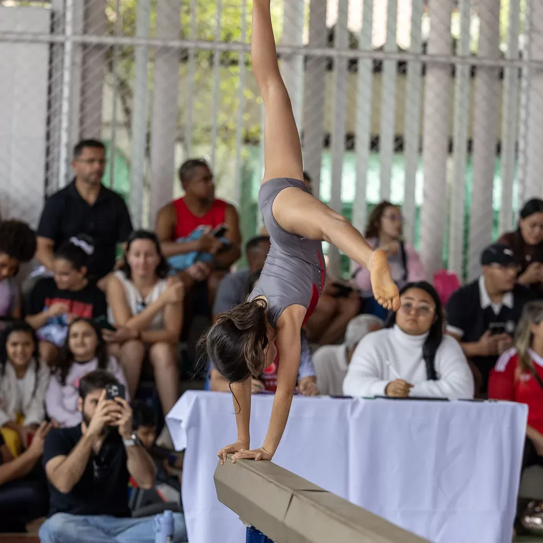 Ginasta em apoio invertido sobre a trave
