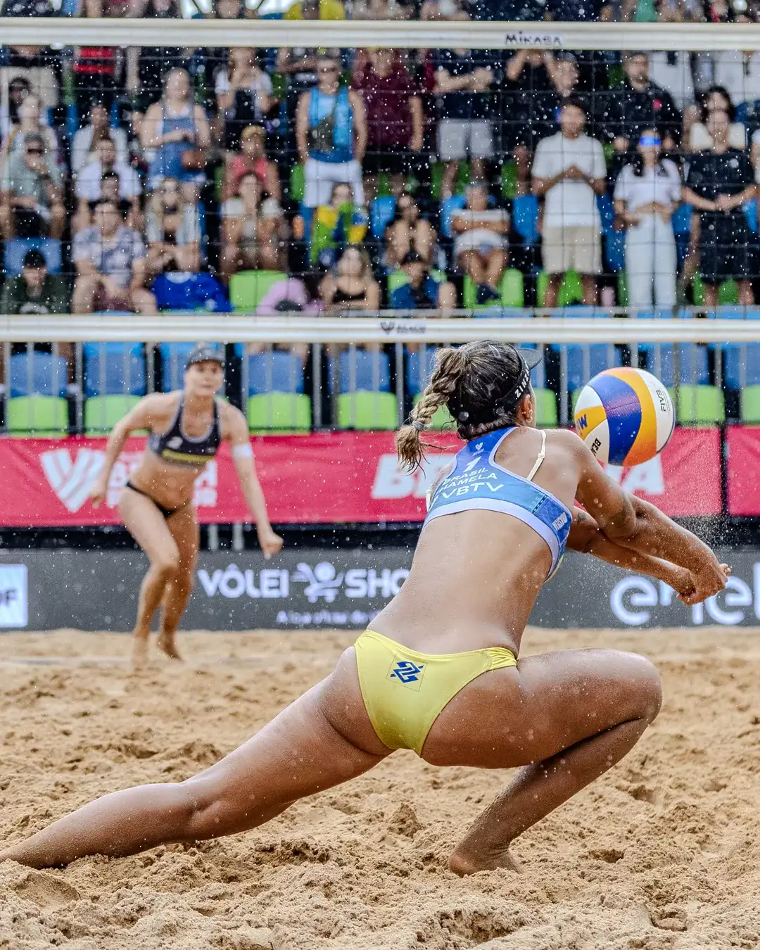 Atleta se joga na areia para defender