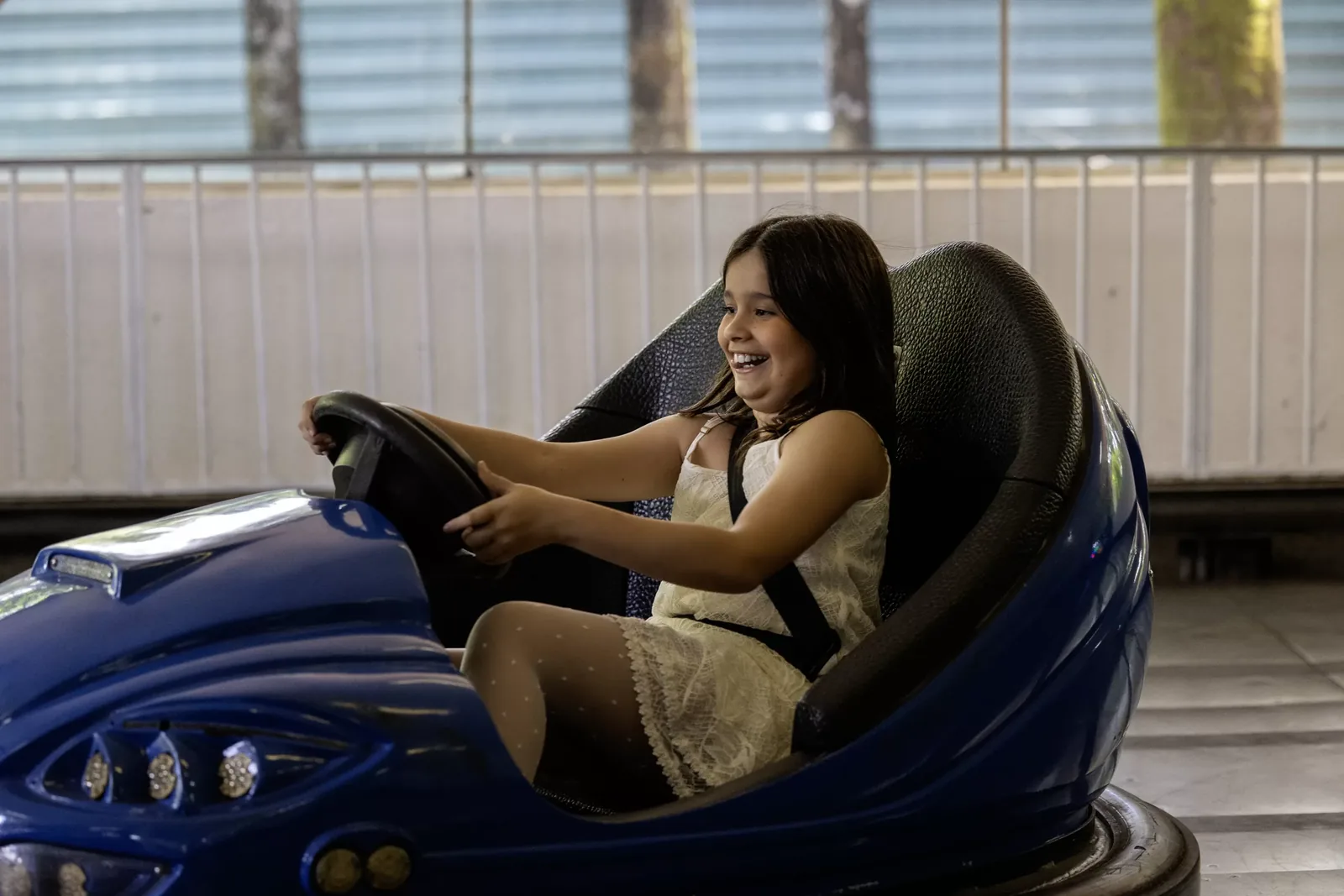Criança sorrindo no carrinho de bate-bate da festa