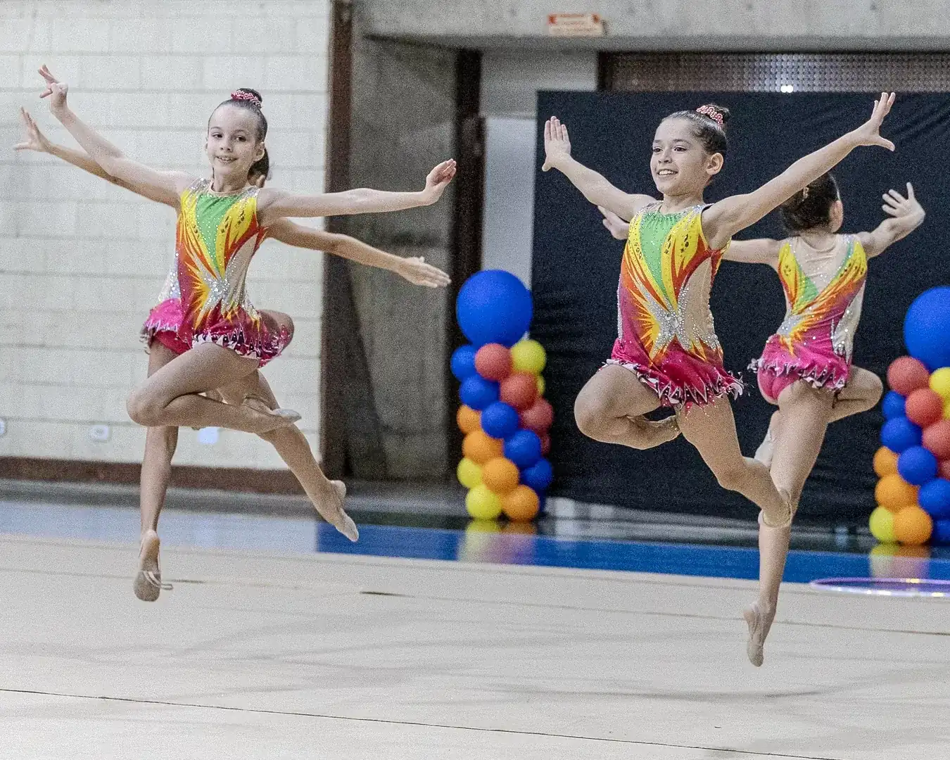 Três ginastas em salto na mesma série