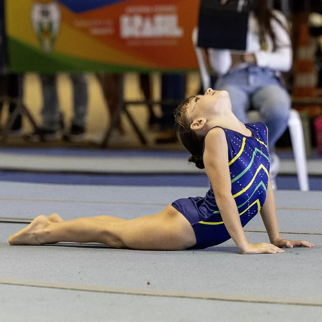 Ginasta em elemento de flexibilidade no solo