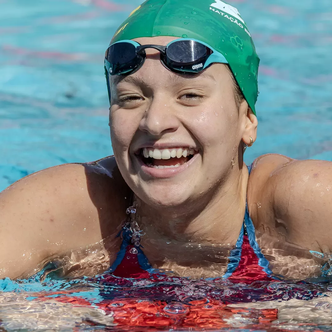 Nadadora sorrindo na água depois da prova