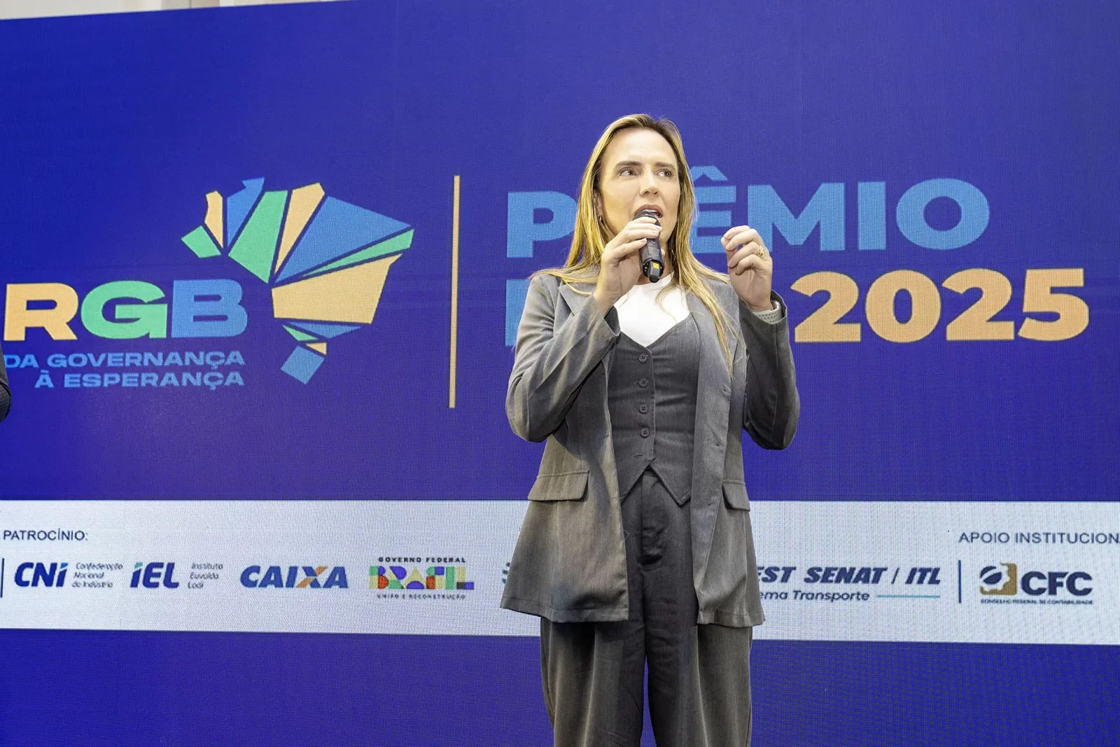 Autoridade discursando ao microfone no palco do 6º Prêmio RGB