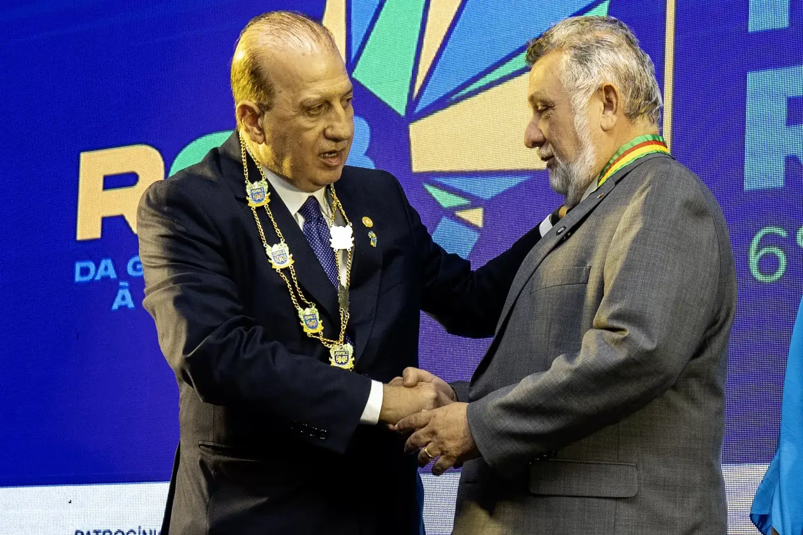 Dois convidados se cumprimentando no palco
