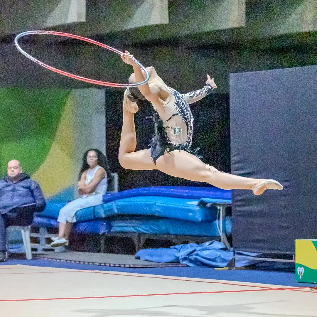 Ginasta em salto atravessando o arco
