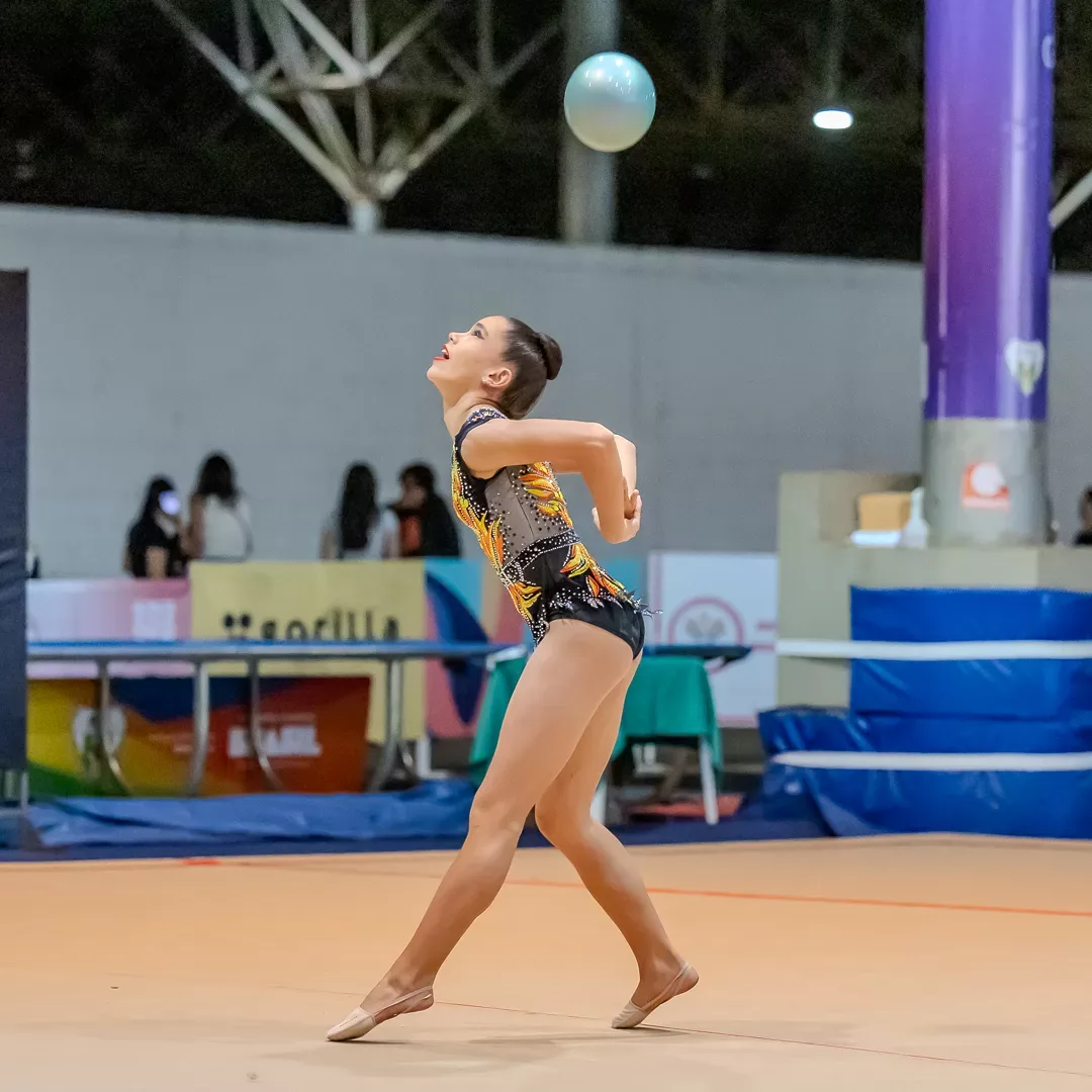 Ginasta lança a bola ao alto durante a série