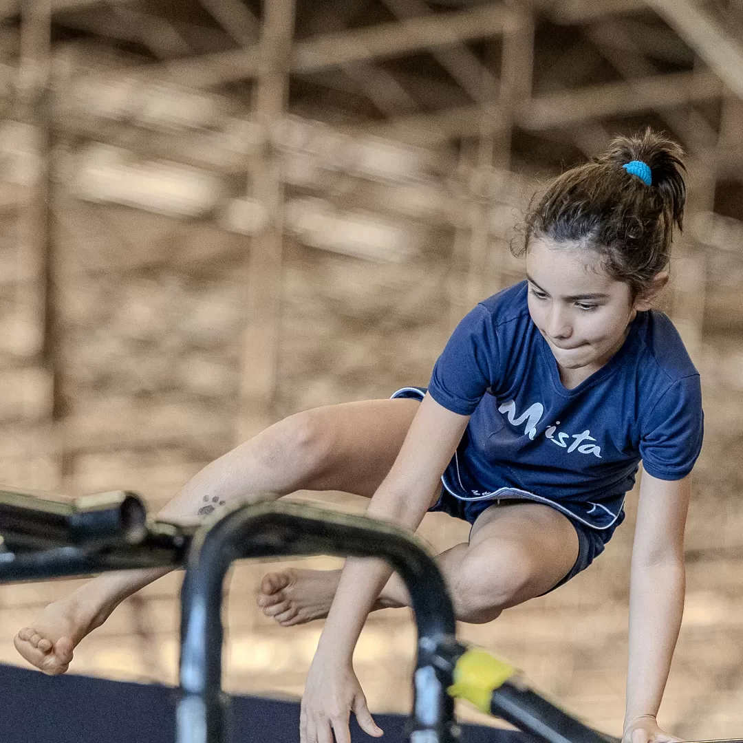 Atleta passando pela barra com o corpo recolhido