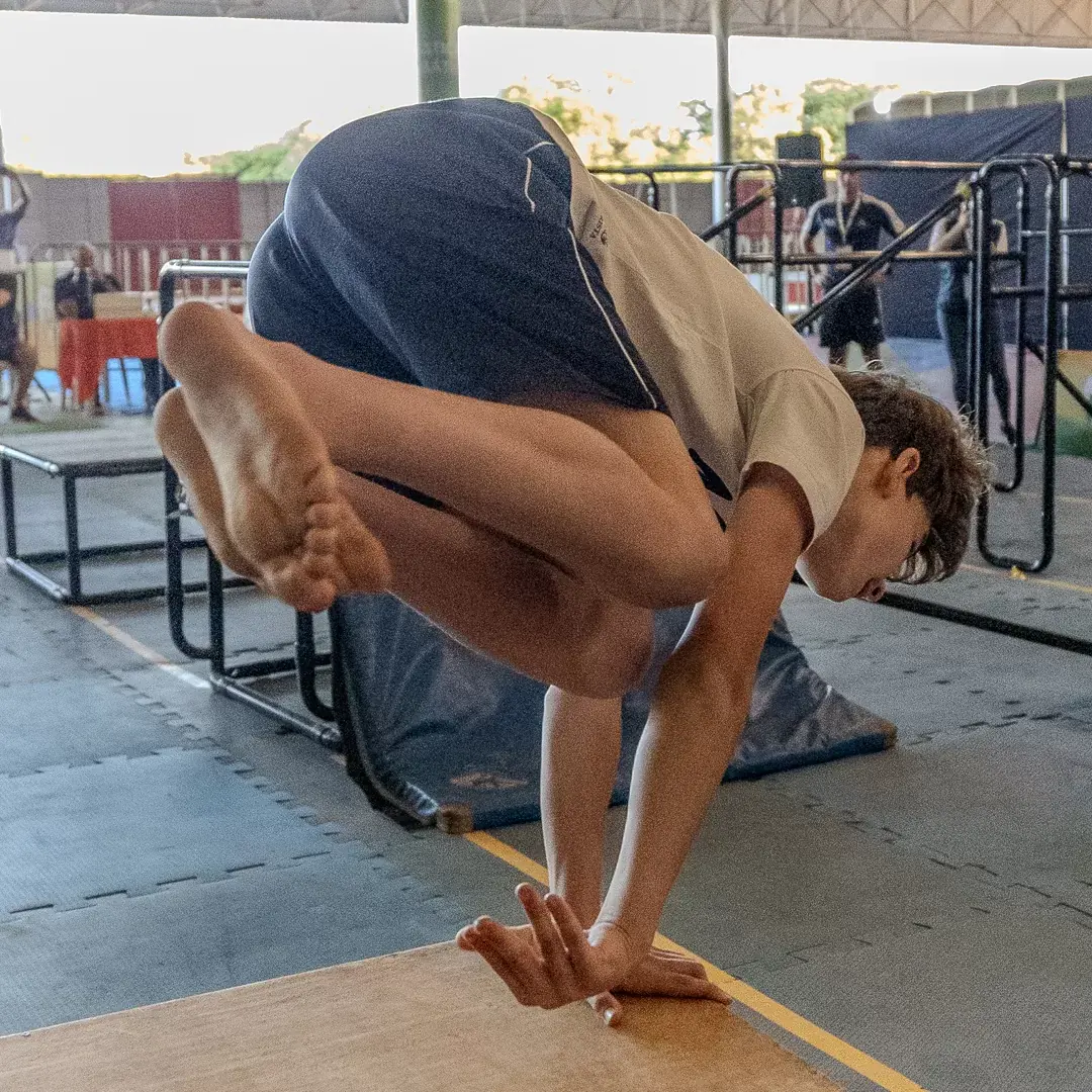 Atleta com o corpo recolhido em cima do módulo