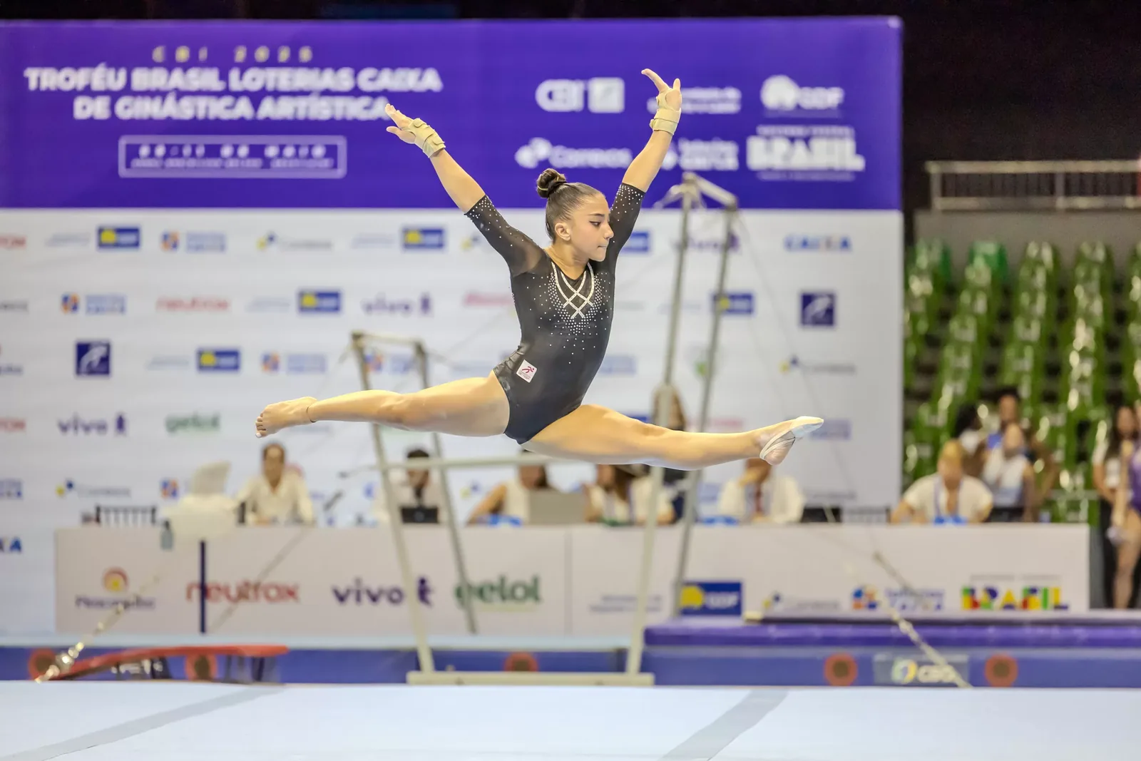 Ginasta em salto com as pernas em afastamento