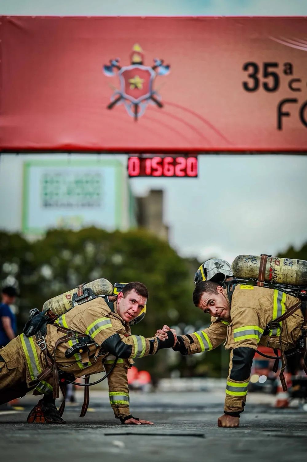 Dois bombeiros se cumprimentando na linha de chegada