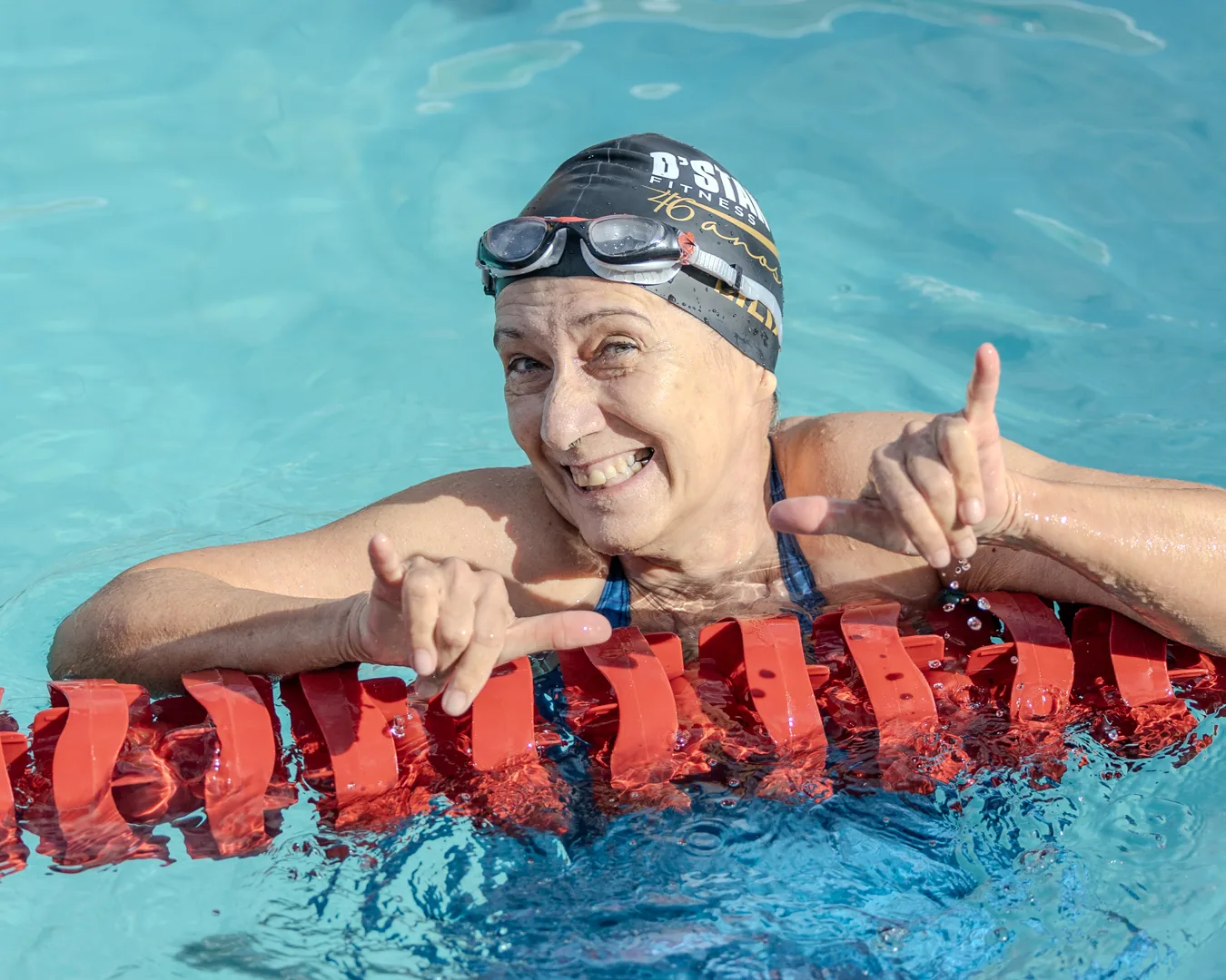 Atleta master sorrindo na borda da piscina