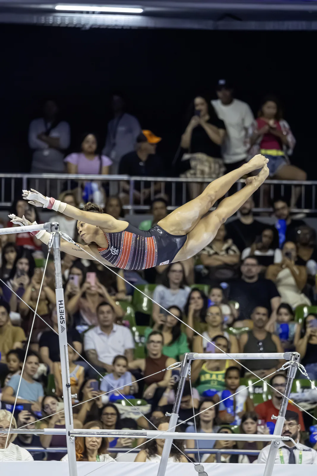 Ginasta em voo entre as barras assimétricas