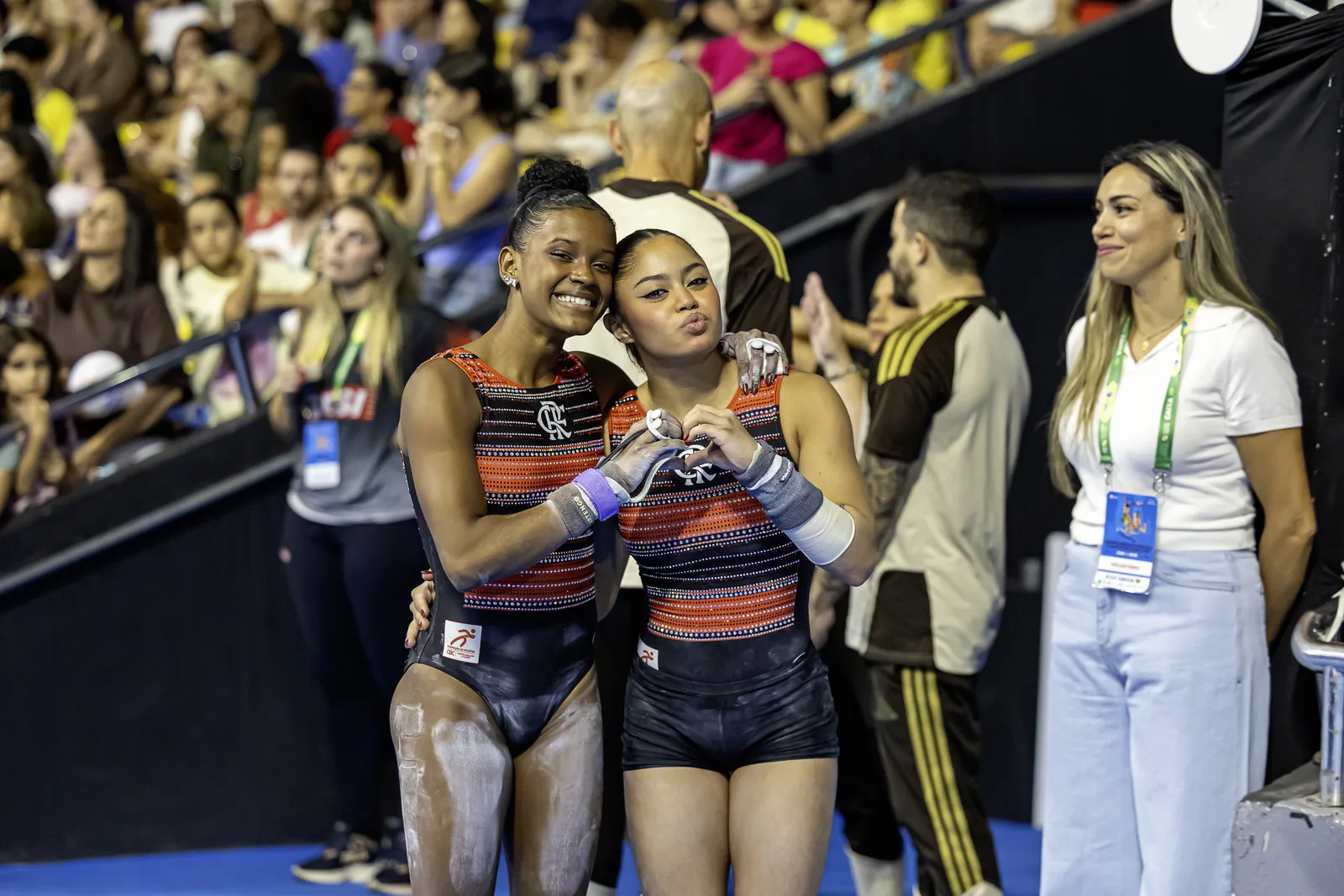 Duas ginastas do mesmo clube abraçadas na saída do aparelho