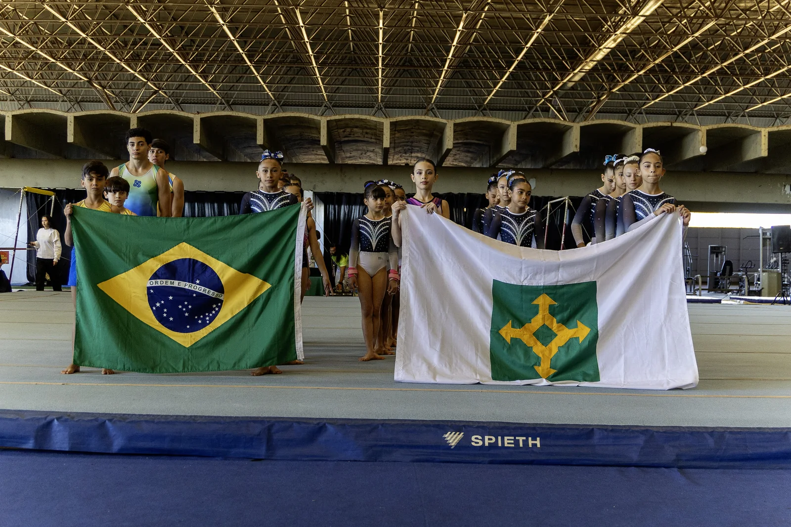 Ginastas segurando as bandeiras do Brasil e do Distrito Federal
